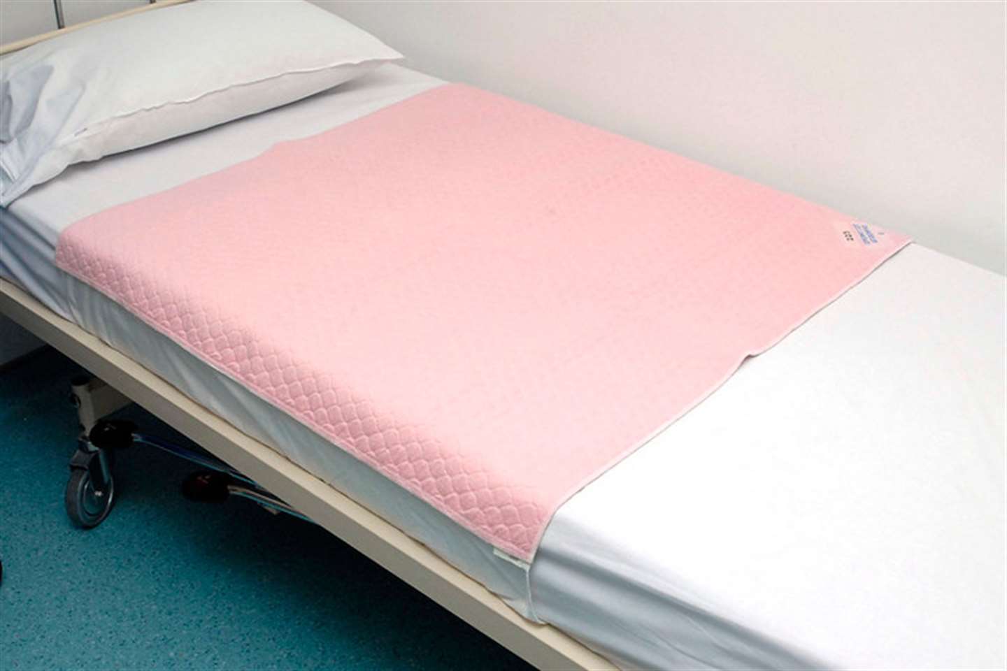 Washable bed pad with integral waterproof backing and tuck in flaps