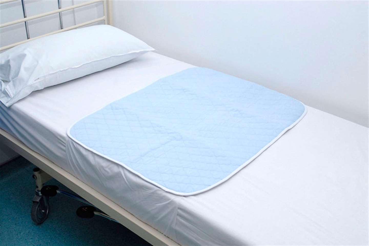 Washable bed pad with integral waterproof backing and tuck in flaps