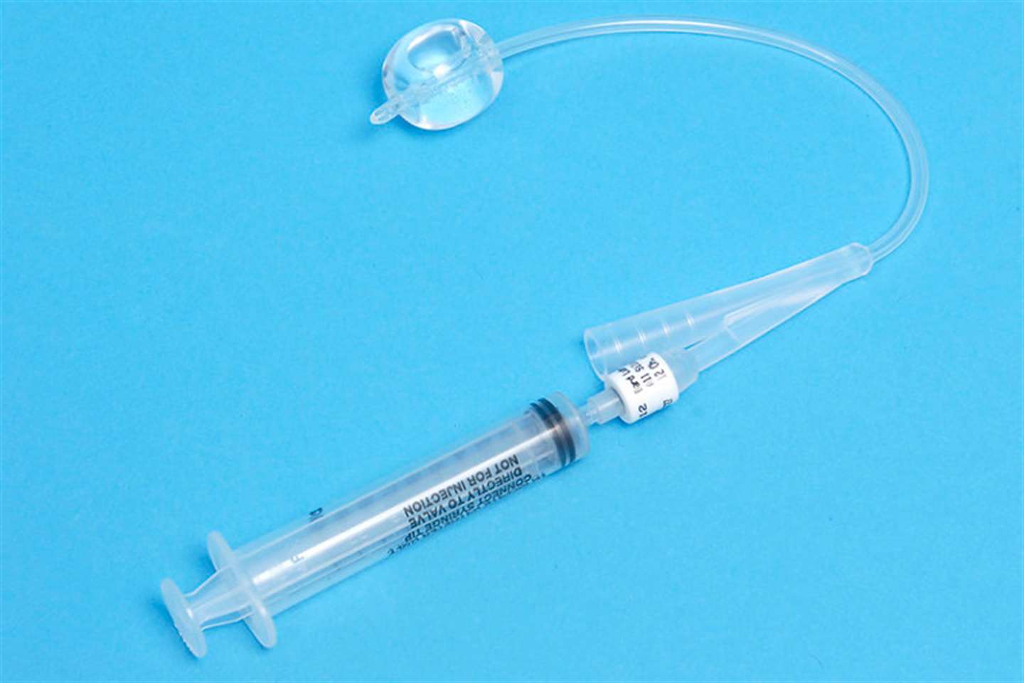 Silicone Foley indwelling catheter showing syringe for balloon inflation