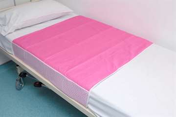 Washable bed pad with integral waterproof backing and tuck in flaps