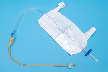 Foley indwelling catheter connected to a body-worn collection bag with leg straps